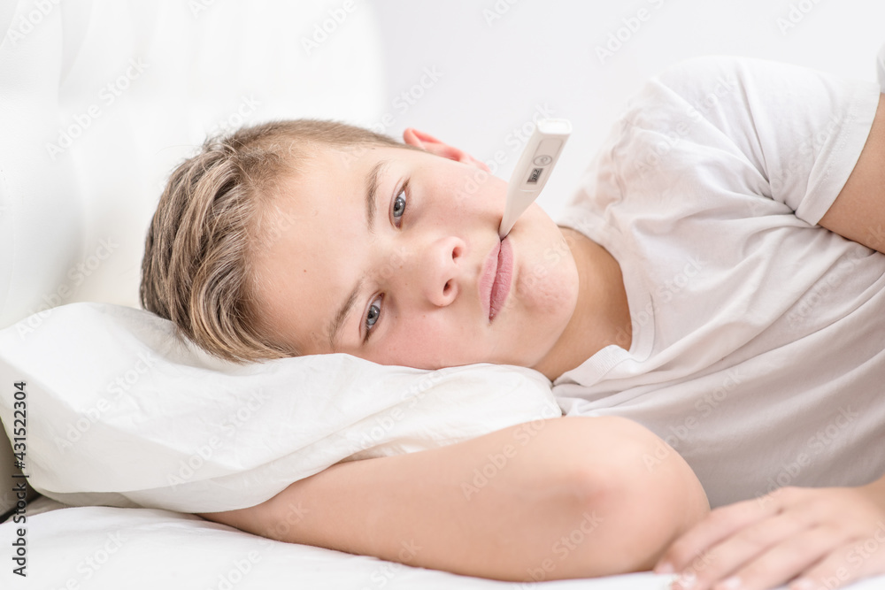 A sick little boy measures the temperature with a thermometer. Cold season. A sick little boy measures the temperature with a thermometer. Cold season.