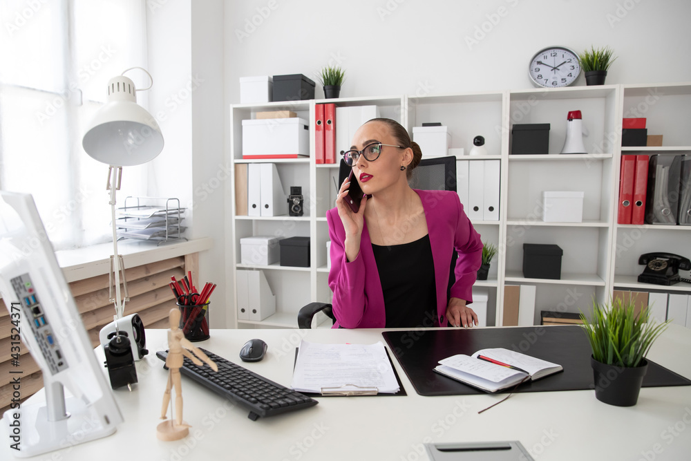 Girl in business style talking on the phone in the office Girl in business style talking on the phone in the office