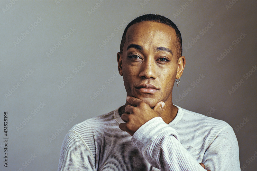 a serious thoughtful man with hand on chin looking at camera studio close up a serious thoughtful man with hand on chin looking at camera studio close up