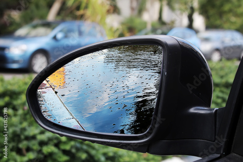 Reflection of a puddle in the side mirror of a car. Сoncept of flooding as a result of an rains in Israel