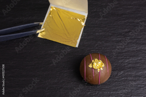 edible gold leaf transfered on a chocolate truffle photo