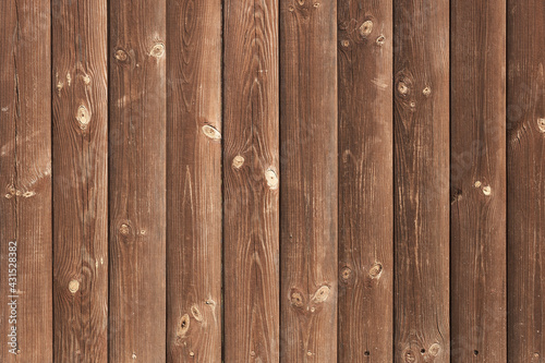 Wooden vertical background with pronounced texture. Brown vertical planks solid wood knots and cracks. The micro-texture of the tree is a pronounced relief.