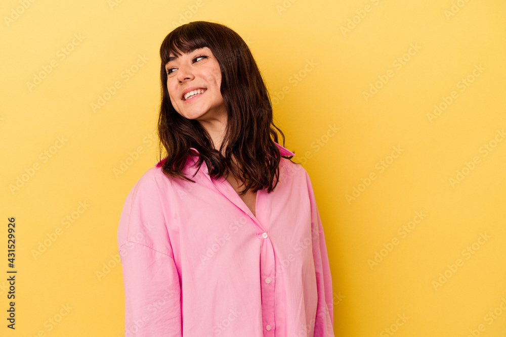 Young caucasian woman isolated on yellow background laughs happily and has fun keeping hands on stomach. Young caucasian woman isolated on yellow background laughs happily and has fun keeping hands on stomach.