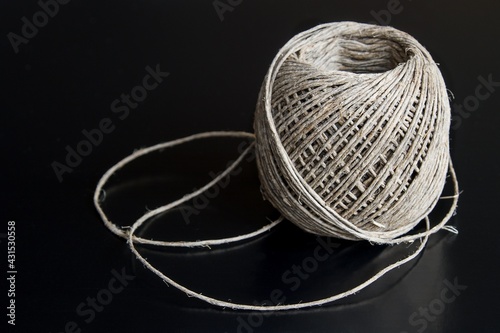A ball of cord made of natural hemp on a black background