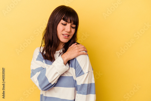 Young caucasian woman isolated on yellow background having a shoulder pain. © Asier