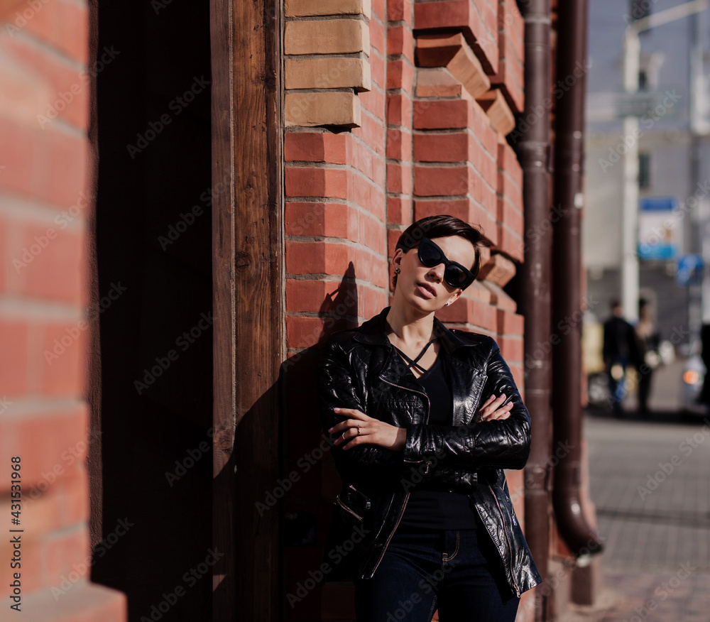 trendy woman in luxury sunglasses, leather jacket