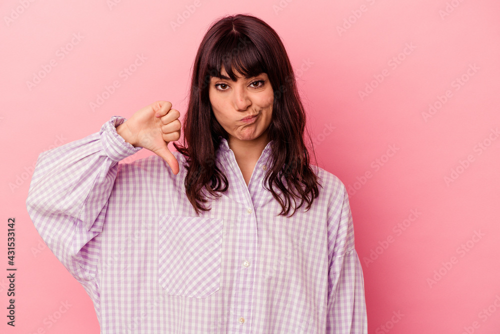 Young caucasian woman isolated on pink background showing thumb down, disappointment concept. Young caucasian woman isolated on pink background showing thumb down, disappointment concept.
