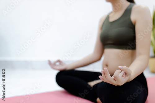 Asian pregnant women relax exercising yoga for good health and her baby enjoying future life. Motherhood, pregnancy, yoga concept.