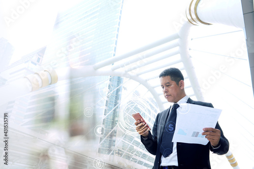 Asian business men aged 40-50 use the phone to talk to the team. With a backdrop of a city view in Thailand photo