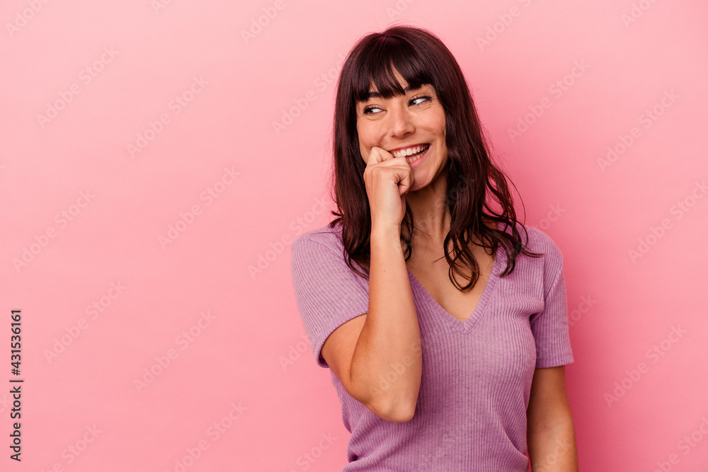 Young caucasian woman isolated on pink background relaxed thinking about something looking at a copy space.