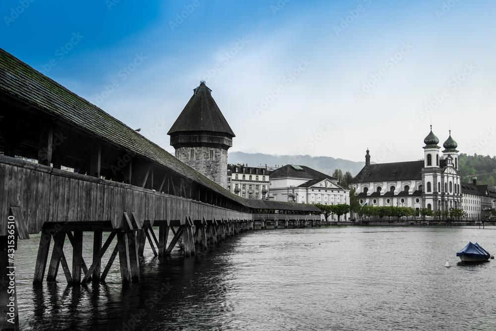 Landscape view of the Kappelbrücke (chapel bridge) of Luzern, with the Reuss river in the foreground, shot in Luzern, Switzerland