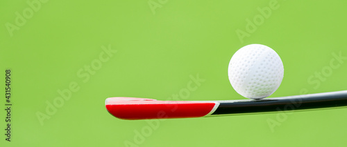 Cuadro en lienzo Field hockey stick and ball on green background