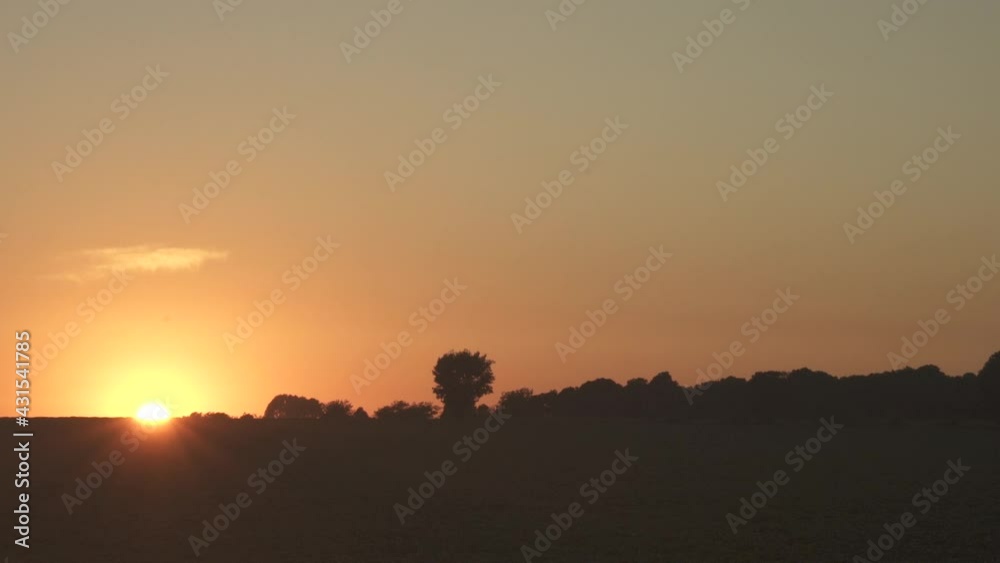 Timelapse of the sunrise on a clear day with orange sky on the countryside Timelapse of the sunrise on a clear day with orange sky on the countryside