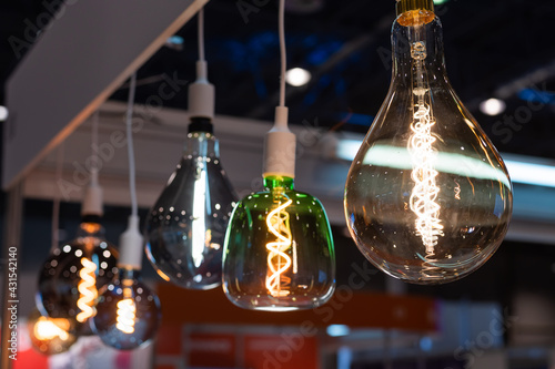 Many differently shaped incandescent bulbs are suspended in the dark