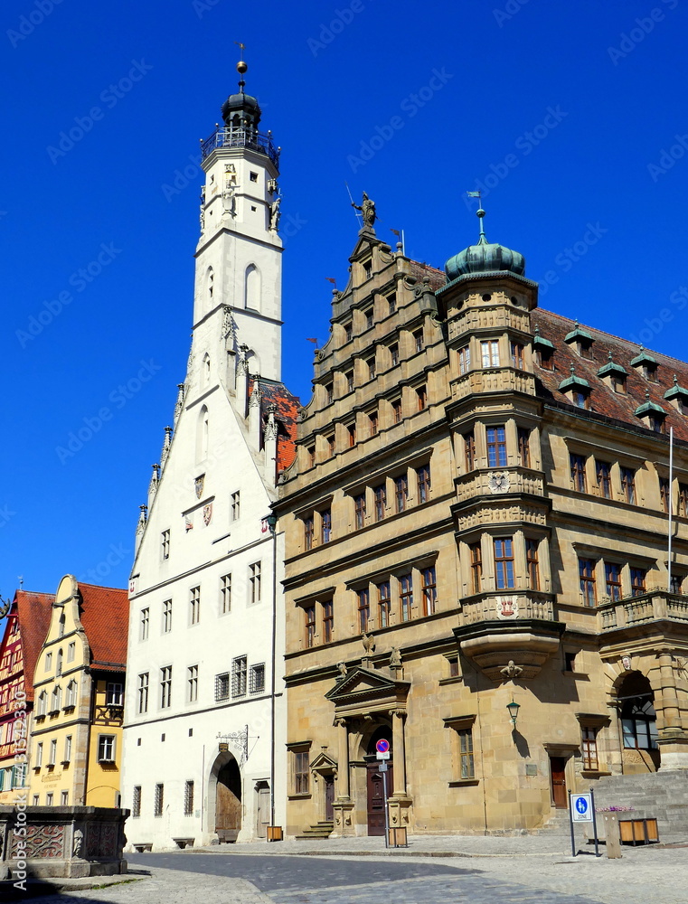 Rathaus mit weißem Turm in Rothenburg und schönem  Marktplatz unter blauem Himmel
