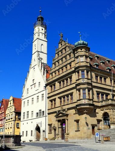 Rathaus mit weißem Turm in Rothenburg und schönem Marktplatz unter blauem Himmel