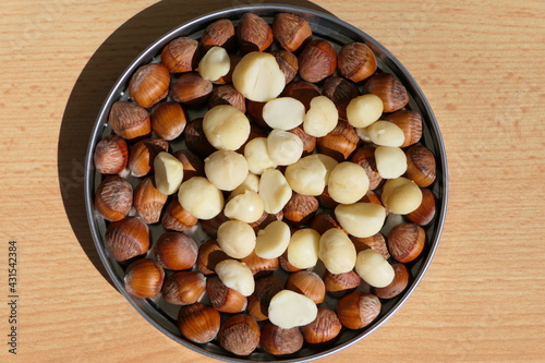 Shelled macadamia nuts, also called Queensland nut or Hawaii nut, in a tin with hazelnuts