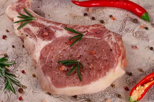 Raw meat for steak with ingredients for cooking on a light background. Bone steak.