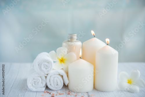 Spa coconut products on light wooden background. Composition with towels, flowers and salt, candle on massage table in spa salon