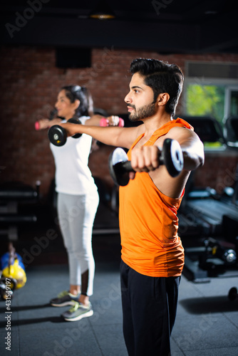 Portrait of Indian asian young Couple working Out Together in Gym, Training With fitness Equipments