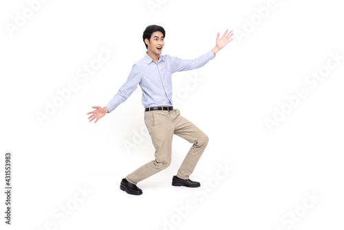 Full length portrait of a cheerful excited Asian businessman standing and presenting with two hands isolated over white background