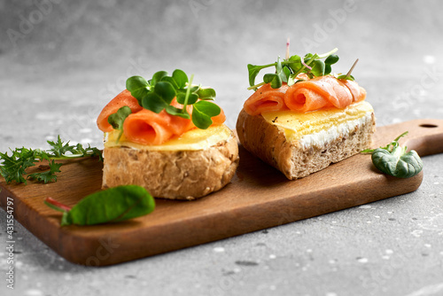 Bruschetta with salmon. Whole grain bread with salmon, cheese on a wooden board.