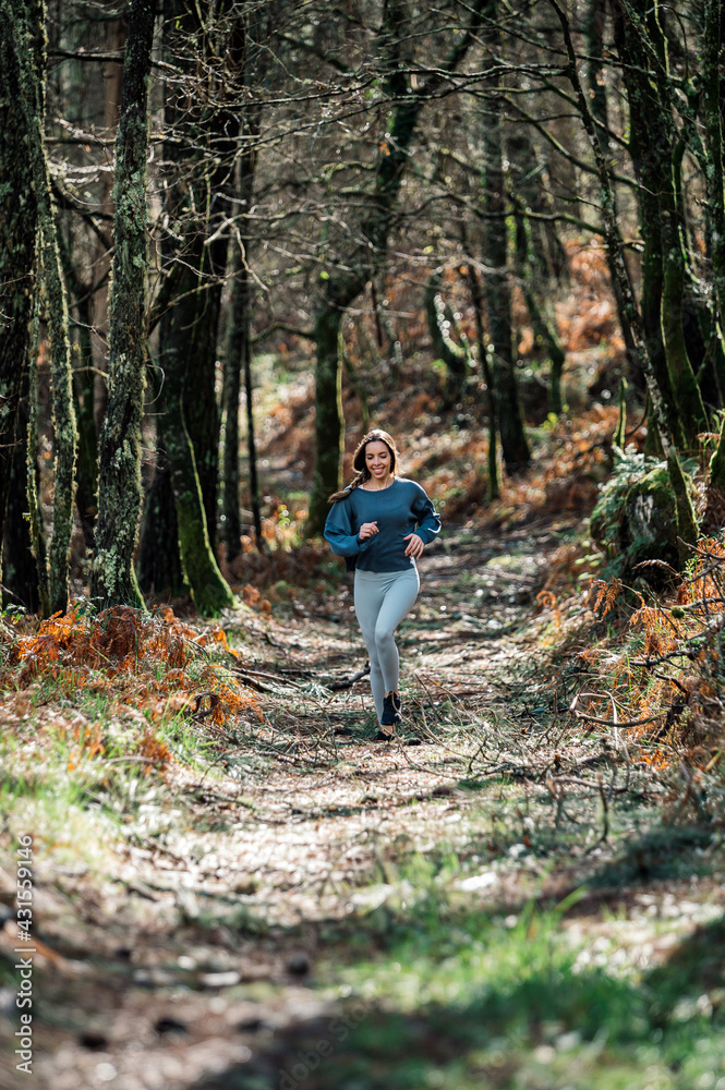 Sporty woman running in forest