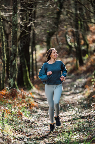 Sporty woman running in forest