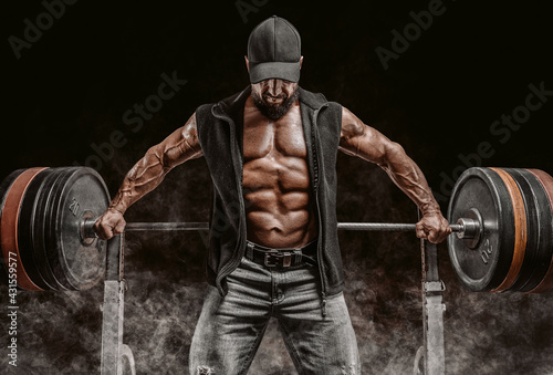фотографія Muscular bearded man stands near the barbell