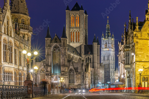 Ghent (Gent) city center at night with blurred motion of people and transportation vehicles with Saint Bavo Cathedral and belfry, East Flanders, Belgium. © SL-Photography