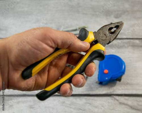 Locksmith iron pliers in the hand of a man.