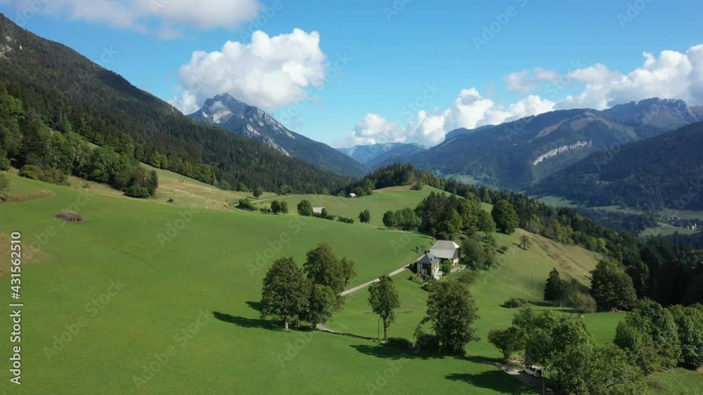 Une route menant à un chalet entouré des prairies en herbe, des forêts et des montagnes verdoyantes verdoyantes vers Saint-Pierre-d'Entremont, dans le massif de la Chartreuse, dans les Alpes, en Isère