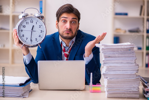 Young businessman employee unhappy with excessive work in the office