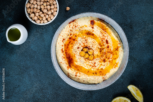 Traditional Middle east appetizer Hummus served with lemon and tahini, seasoned with extra virgin olive oil and paprika in ceramic plate. eastern dish. Vegetarian dish. Traditional dip with chickpea
