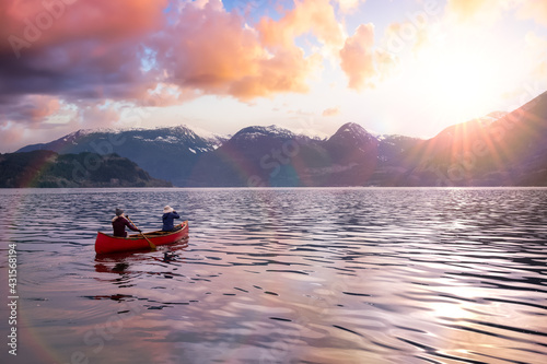 Adventurous people on a canoe are enjoying the beautiful Canadian Mountain Landscape. Taken in Squamish, North of Vancouver, British Columbia, Canada. Sunset Sky Art Render