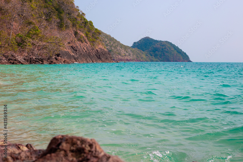 Seascape.Turquoise sea water among the mountains on the tropical island of Koh Chang, rocky coast on a sunny day. Travel and tourism concept