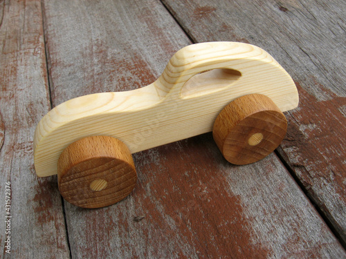 A wooden toy car on a wooden board background