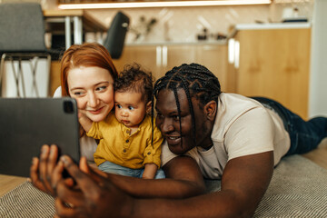 Close-up image of diverse family taking picture over digital tablet.