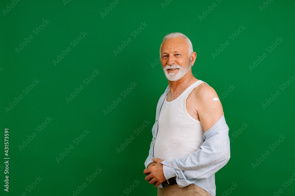 Green background, man standing and looking at camera.