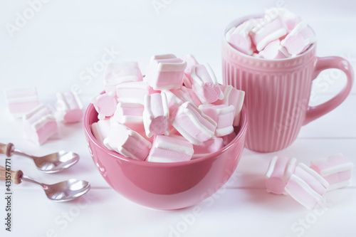 marshmallow in pink cups close-up. background with pink and white marshmallows in bowls on a white background.