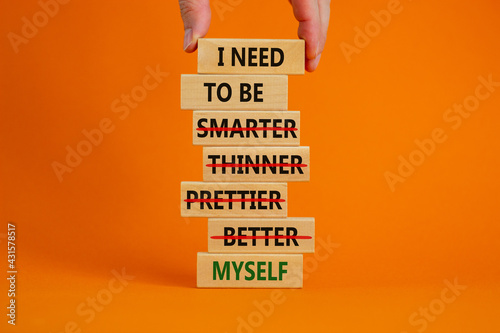 Be myself symbol. Businessman hand. Wooden blocks with words 'i need to be myself, not smarter, thinner, prettier, better'. Beautiful orange background, copy space. Psychological, be myself concept. photo