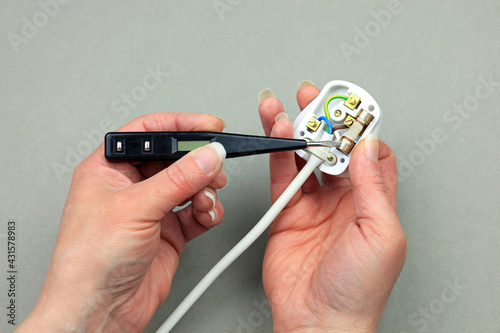 Fotografie A Female Electricians Hands Testing A Fuse In An Electrical Appliance