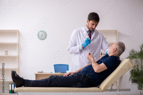 Old male patient visiting young male doctor in vaccination conce