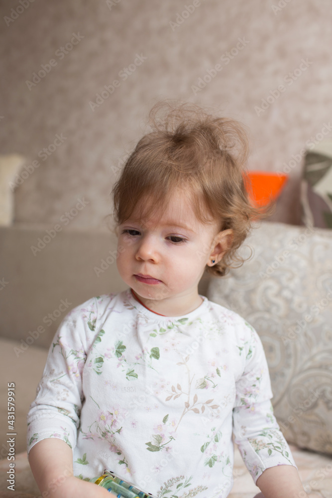 large portrait of a little girl in a room near the sofa