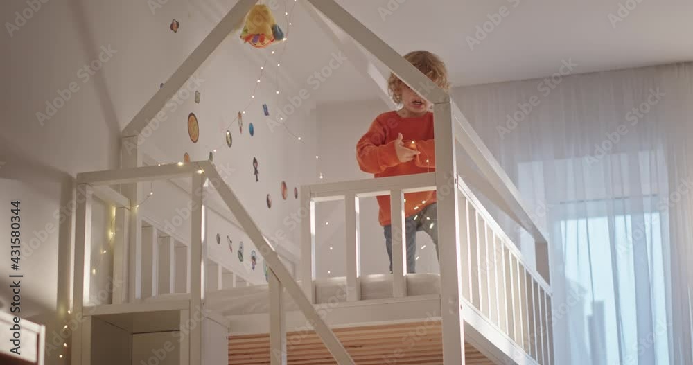 Boy decorating bed with fairy lights