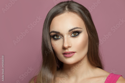 Perfect woman face with makeup on pink background