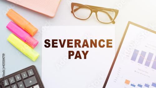 The text - Severance Pay on office desk with calculator, markers, glasses and financial charts.