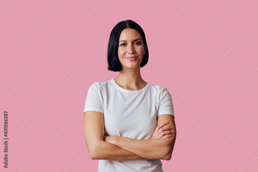 portrait of a beautiful young woman with arms crossed isolated on pink background portrait of a beautiful young woman with arms crossed isolated on pink background