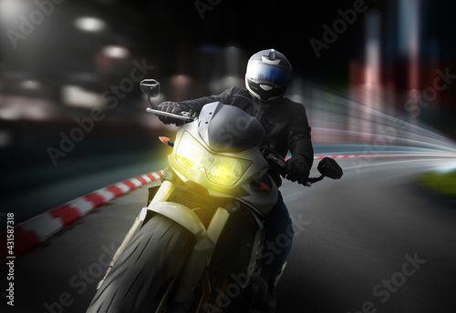 Big motorbike riding fast through the dark streets of the city - lights pass by.  