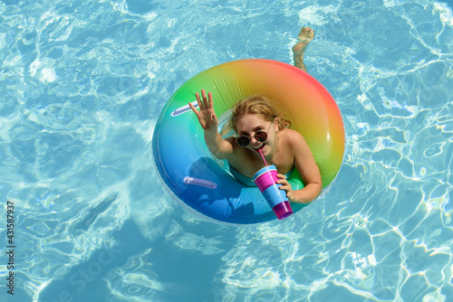 Happy summer mood. Pool resort. Enjoying vacation. Woman in swimsuit on swim ring in the swimming pool.